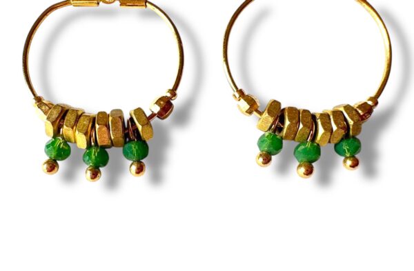 Boucles d'oreilles créoles dorées avec écrous en laiton et trois perles vertes vues de près.