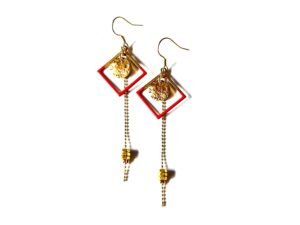 Boucles d'oreilles pendantes carrées rouges avec écrous en laiton brut et chaîne dorée.