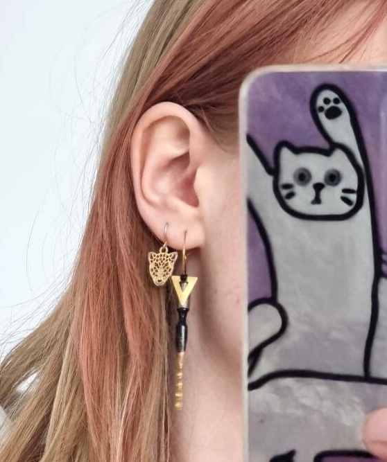 Les boucles d'oreilles plumes noires portées par Aurélie.