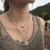 Collier porté ras du cou, couleur rouge.