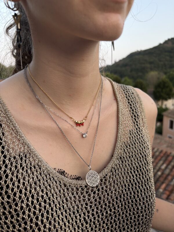 Collier porté ras du cou, couleur rouge.