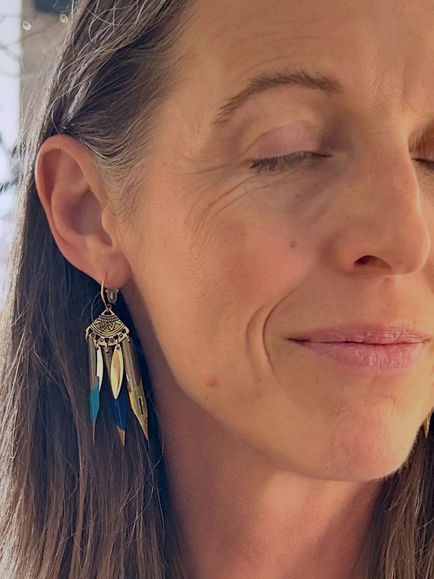 Ana porte les boucles d'oreilles plumes